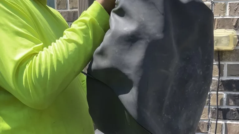 Closeup of a Texan Mosquito Systems technician diagnosing a worn misting nozzle and replacing fittings during a system repair